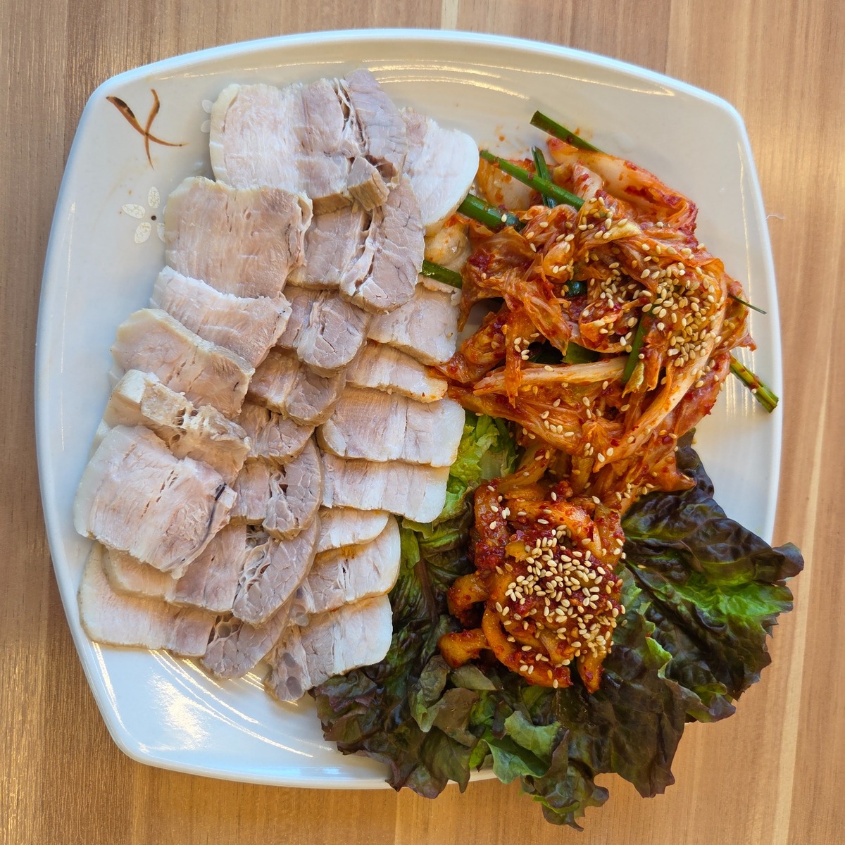 김치와 쌈채소를 곁들인 수육 한 접시